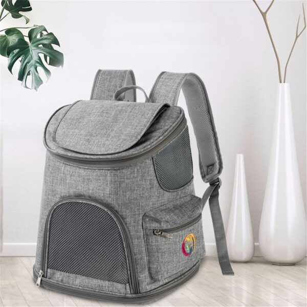 Sac à dos gris chiné à rabat posé sur un parquet clair, près d'un vase blanc et d'une plante, fenêtre en maille sur l'avant