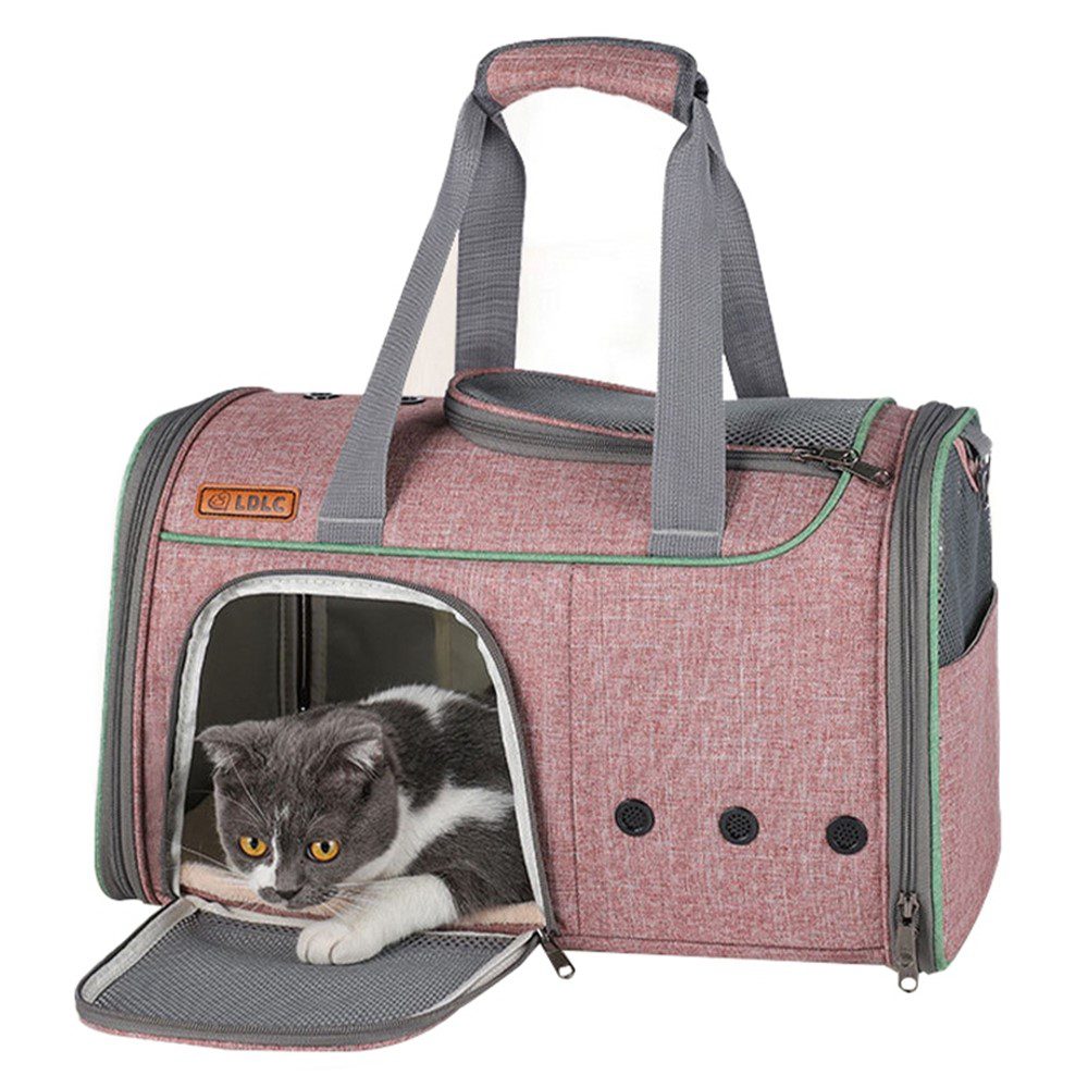 Gros plan d'un sac rose à fermeture vert menthe, panneau d'entrée rabattu et chat aux yeux jaunes qui regarde l'objectif