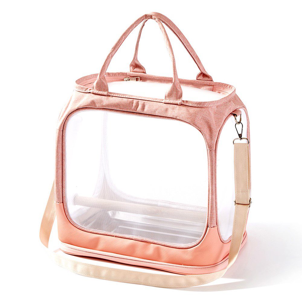 Sac de transport rose pâle, panneau avant transparent, poignées rembourrées et bandoulière claire repliée au pied
