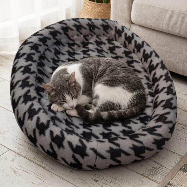 Chat gris et blanc couché dans la corbeille fourrure pour chat à motif pied-de-poule