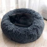 Chat noir endormi dans le lit rond donut en peluche grise