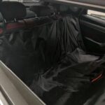Housse noire installée sur la banquette arrière d'une voiture, rabats latéraux déployés