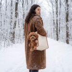 Femme avec manteau moumoute portant sac chien ours peluche bandoulière