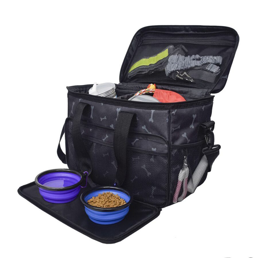 Sac de voyage noir à motifs d'os gris, couvercle ouvert sur accessoires, avec deux gamelles pliantes bleu-violet dépliées
