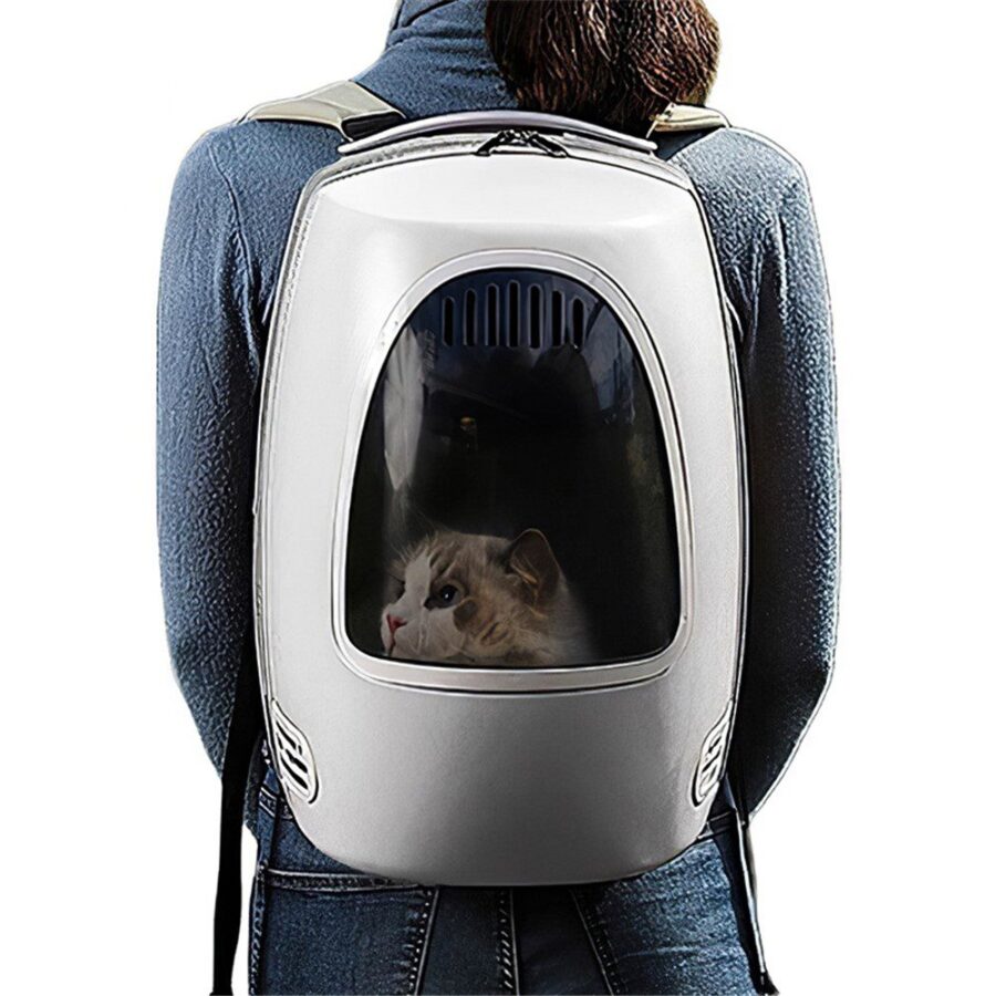 Personne de dos portant un sac à dos blanc en forme de capsule, hublot transparent derrière lequel se tient un chat blanc