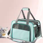 Sac de transport turquoise à fenêtres en filet et deux anses grises, un chat gris et blanc au premier plan à gauche