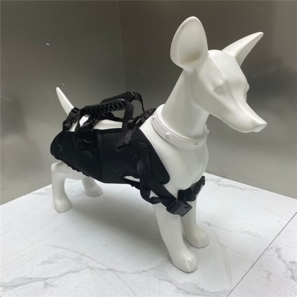 Mannequin de chien blanc portant un harnais noir avec poignée de dos et boucles de sangle, sur un sol de marbre